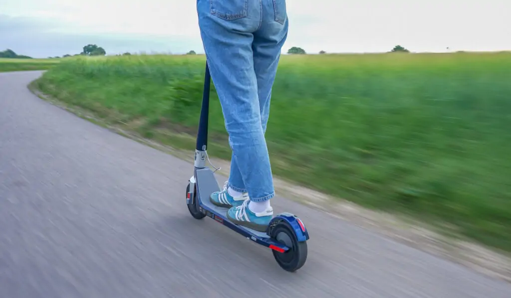girl riding an unagi model one electric scooter on the road